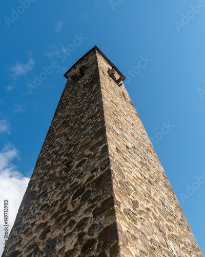 Stone tower against blue sky. Medieval stone building.