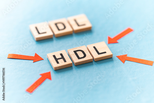 Concept of difference between HDL and LDL cholesterol, with terms composed with wooden alphabet on a blue background, good cholesterol HDL.
