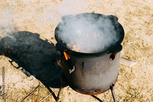 Meat cooking in cauldron outdoor. Plov recipe with meat. Cooking food street. Traditional cuisine and oriental dish.