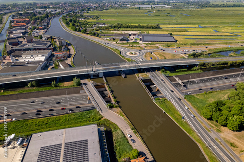 Aerial Dutch landscape with Gouwe aquaduct seen from above. Inland shipping waterway infrastructure for over and under freeway intersection with commute traffic passing by