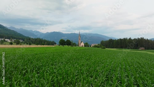 Pastoral drone establishing over San Valentino church near Pfalzen in the Dolomites, Italy