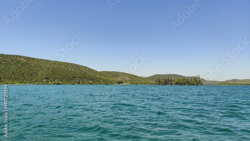 Visovac monastery island on krka river reflecting on turquoise water in croatia