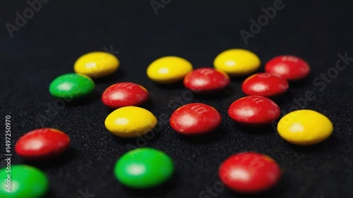 Colorful chocolate candies scattered on a dark surface, evoking sweetness, indulgence, and fun. Ideal for food, confectionery, and children's themes.