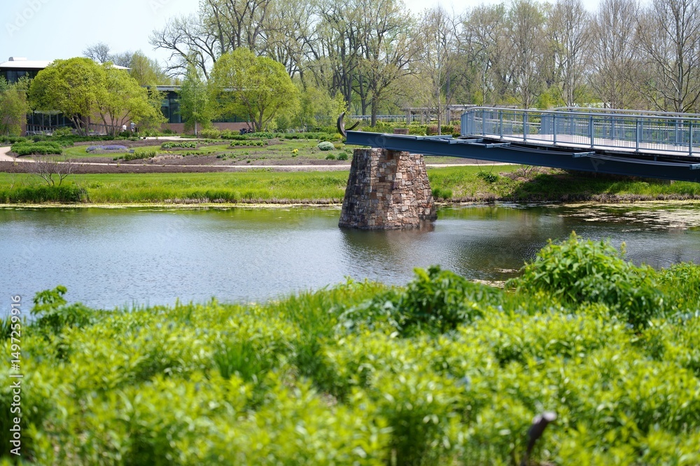 Fototapeta premium Scenic park view with modern bridge and pond.