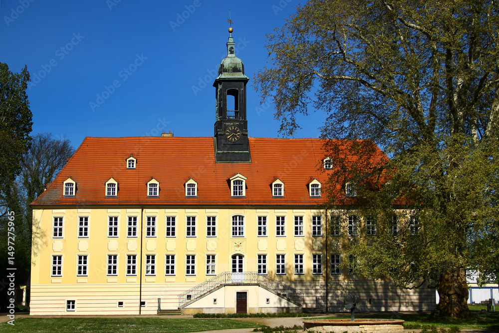 Obraz premium Schloss Elsterwerda with baroque architecture and clock tower under a clear blue sky in Elsterwerda, southern Brandenburg, Germany