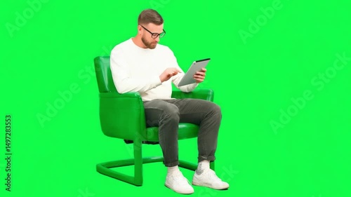 Man with a Digital Tablet: A focused man, seated comfortably, interacts with a digital tablet, showcasing modern technology in a vibrant, isolated setting. 