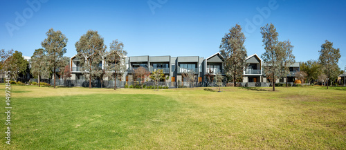 Photos Wide green lawn in front of contemporary townhouses in a suburban neighborhood