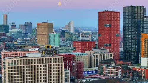 aerial video of manchester northern quarter area cityscape with a full moon on the horizon