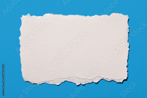 Torn white blank paper on blue background
