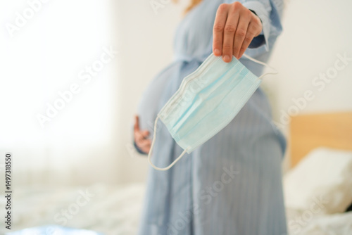 Konstfotografi Mom-to-be wearing safety mask while recovering in bed
