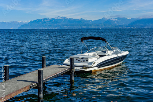 Bateau de plaisance amarré à un ponton en bois sur les rives du lac de Genève