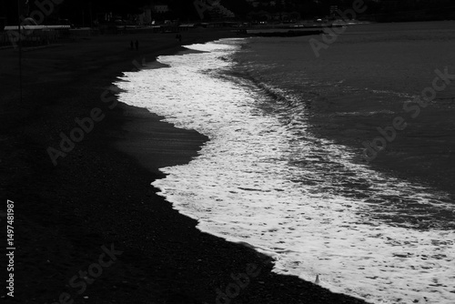 sea ​​waves on the beach with dark colors, from the white of the sea to the black of the beach