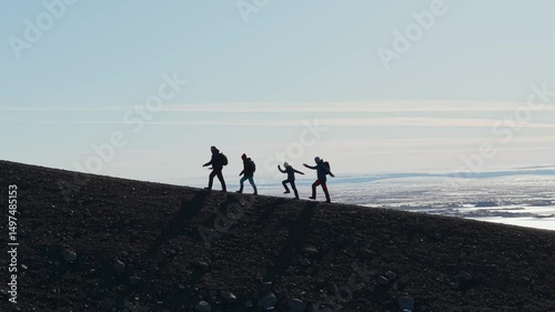 Tourists are happily and joyfully climbing the mountain. A group of tourists climbs the volcano Hverfjall in Iceland. Tourism, expedition, travel and adventure concept.