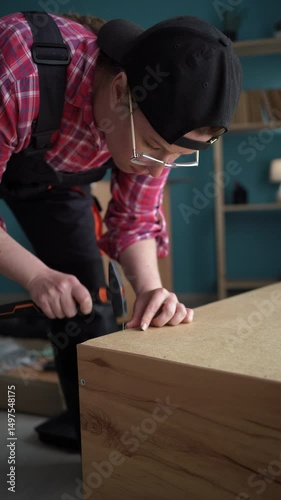 woman assembling furniture at home. using hammer for assembling.