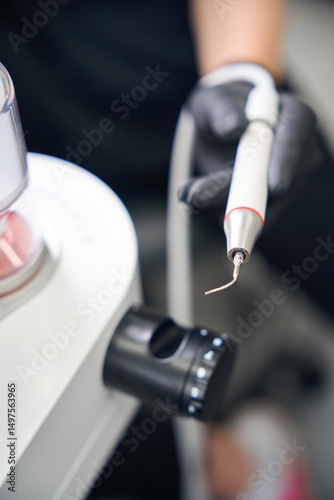 Experienced dentist choosing the nozzle of ultrasonic scaler