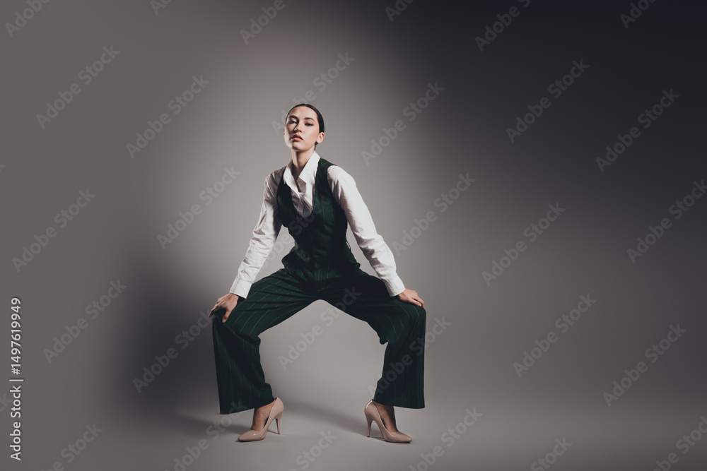 Confident Businesswoman in Elegant Waistcoat Posing Against a Minimal Grey Backdrop Confident Businesswoman in Elegant Waistcoat Posing Against a Minimal Grey Backdrop