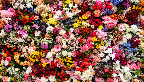 Vibrant multi-colored flower wall background, bright floral decoration for spring and summer