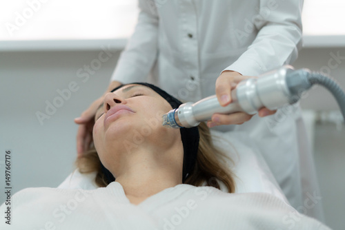 A surgical coagulation therapist is applying a skin treatment device