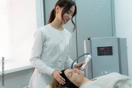 A surgical coagulation therapist is applying a skin treatment device