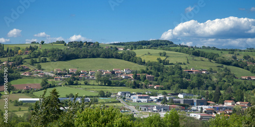Panorama sur un village et une zone industrielle ou commerciale des Monts du Lyonnais