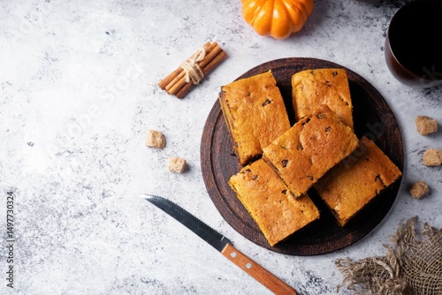 Pumpkin cake with chocolate filling in a plate on a wood cutboard on a grey background