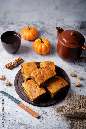 Pumpkin cake with chocolate filling in a plate on a wood cutboard on a grey background