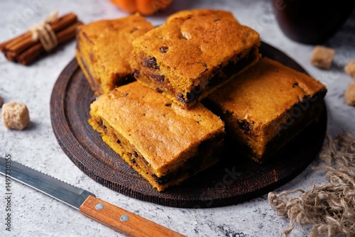 Pumpkin cake with chocolate filling in a plate on a wood cutboard on a grey background