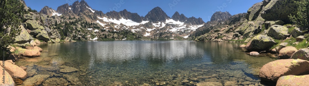 The majestic mountain lake reflects the towering peaks under a clear, bright blue sky, perfect. The majestic mountain lake reflects the towering peaks under a clear, bright blue sky, perfect.