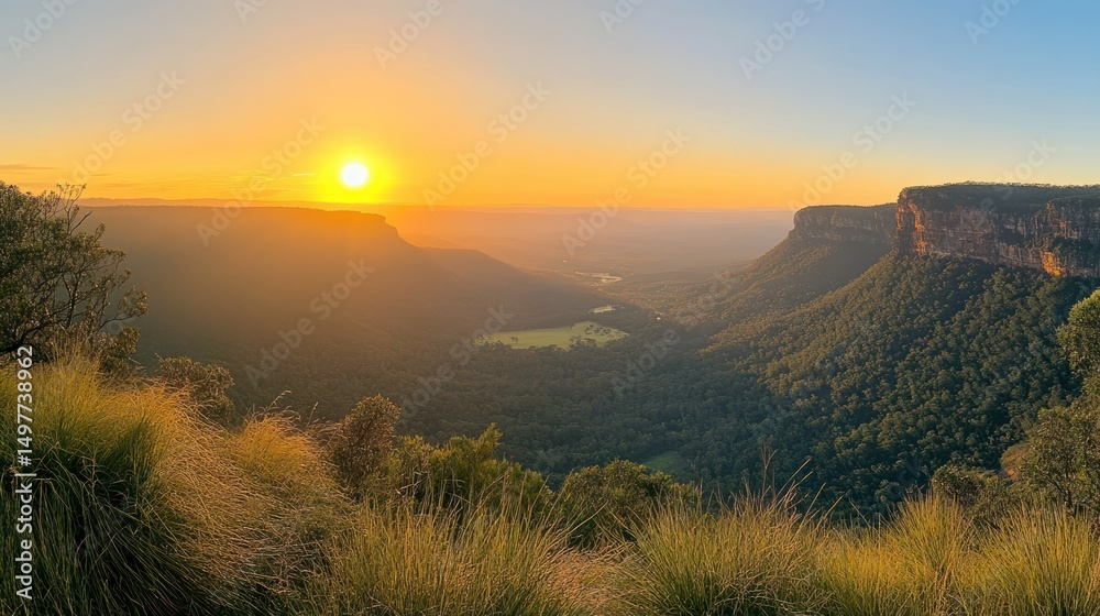 Fototapeta premium A scenic landscape of a valley and mountains at sunset with a golden glow.