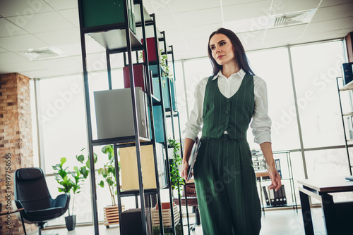 Fotografija Confident businesswoman walking in modern office environment, professionally dre