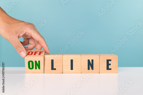 Online and Offline. Hand flipping wooden block with the word OFFLINE to ONLINE at the table in the office