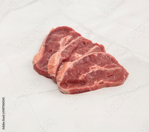 Fresh raw chuck eye steaks on white marble surface ready for cooking – High Resolution Raw Meat Image for Food Industry or Food Packaging