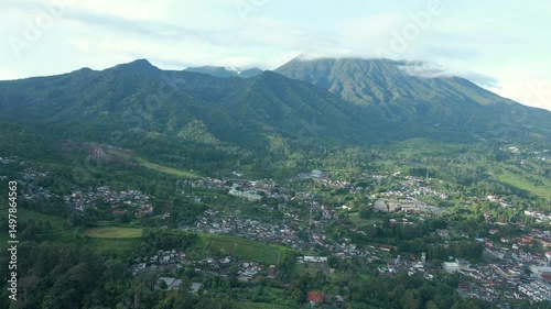Aerial 4K View of Lush Green Mountain Range and Dense Settlement Below

