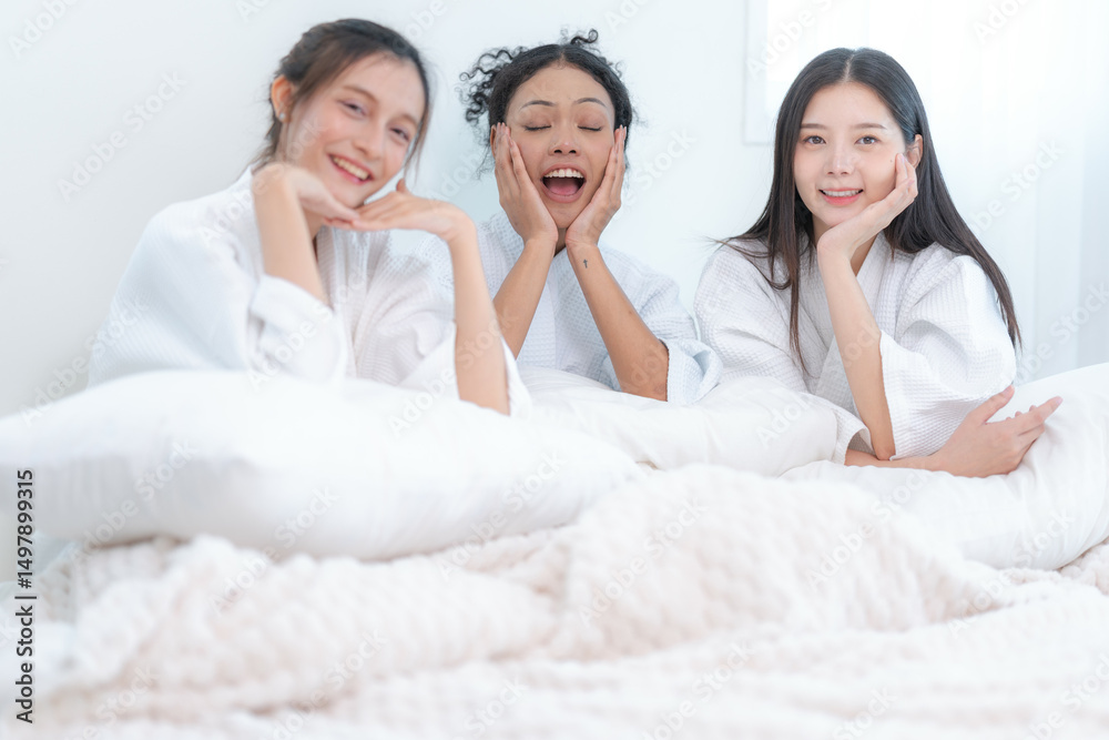 Three diverse women laughing together in white bathrobes, enjoying a joyful spa day or girls' night in with warmth and happiness. Three diverse women laughing together in white bathrobes, enjoying a joyful spa day or girls' night in with warmth and happiness.