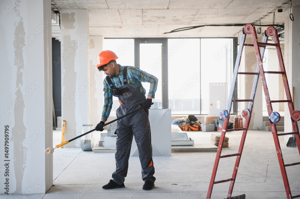 Fotografie Construction worker painting walls with roller in building under construction