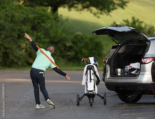A senior golfer stretches before playing in a golf tournament.