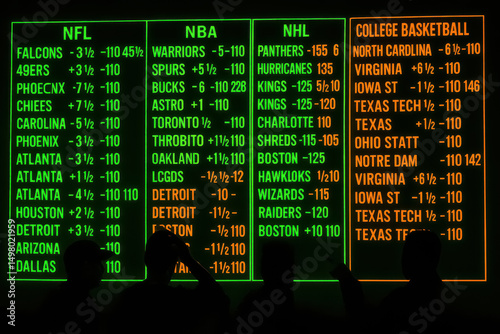Neon-lit sports betting board with silhouettes of viewers