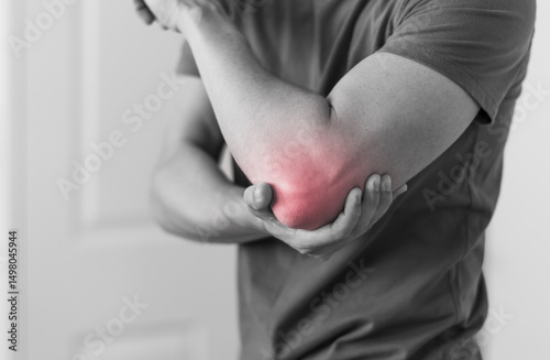 Man with elbow injury showing red highlights pain relief concept concept muscle pain due to lateral epicondylitis or tennis elbow injury, Health care concept 
