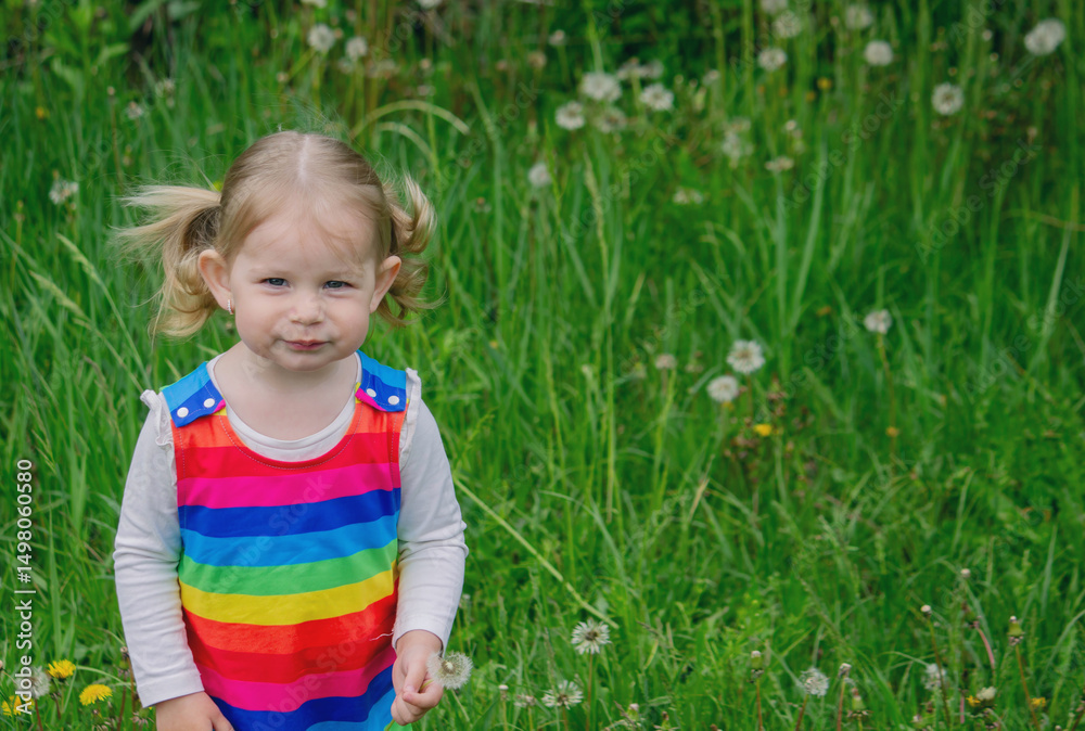 Adorable cute little girl blowing on a dandelion flower on the street in summer. Kid Allergy Adorable cute little girl blowing on a dandelion flower on the street in summer. Kid Allergy