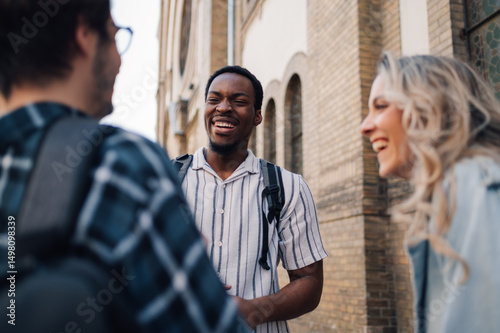 Fototapeta Happy students talking and laughing together outdoors