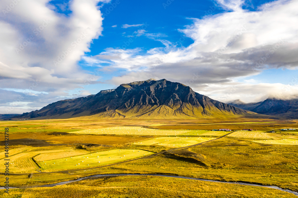 Fototapeta premium Aerial Iceland: Cloudy Skies Over Mountains and Meadows