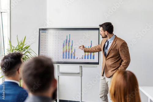 Fotografía Young financial director is pointing and graphs and charts on whiteboard and having presentation for financial report