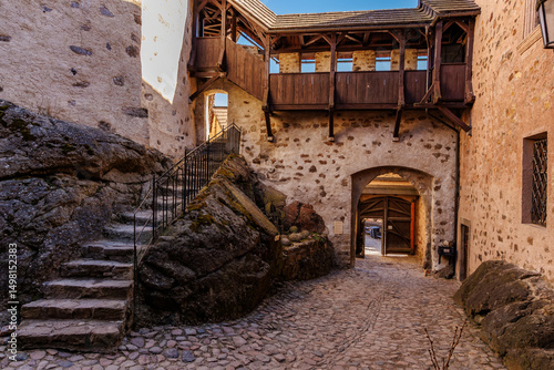 Obraz na plátně Medieval stone castle courtyard with stairway and wooden balcony