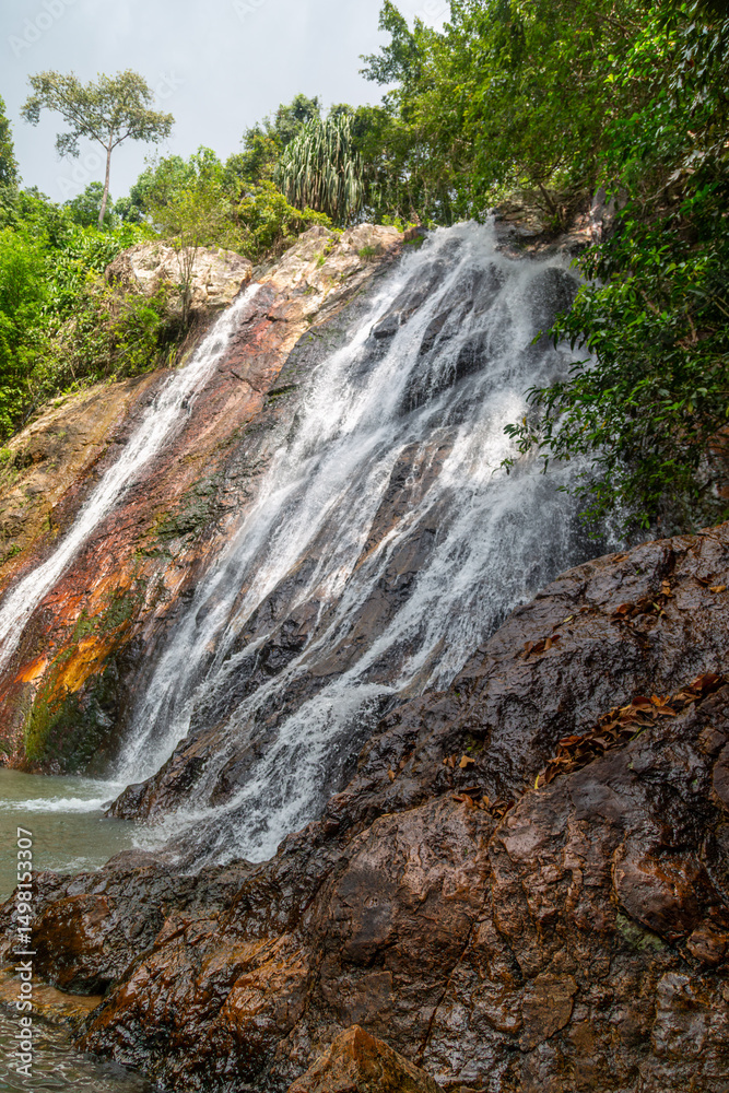 Obraz premium Na mueang waterfall or Na muang 1 waterfall can be seen in the middle of a jungle setting located on the Thai island of Ko Samui