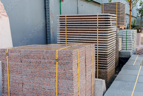 Pallets with stacked gray paving slabs selective focus Stack of paving slabs in warehouse road repair or finished tile sale space for text. High quality photo