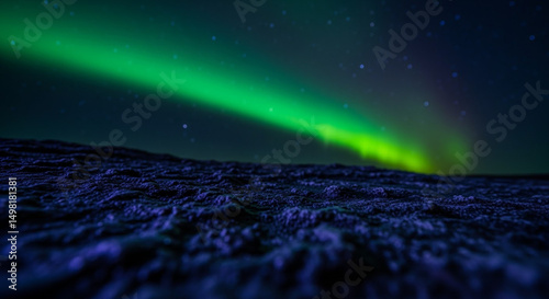 Spectacular green northern lights aurora borealis illuminate dark starry night sky over textured ground