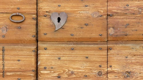 Extreme close-up of an old wooden exterior door with an iron handle and a lock