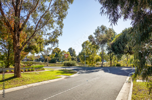 Residential street in suburban Point Cook, Melbourne, Australia, featuring a “Give Way” traffic sign, landscaped verges, and mature eucalyptus trees.Concept of low-traffic neighborhood planning