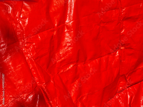 Red background. Red tarpaulin PVC background. Red aesthetic. Red plane surface. Wrinkle texture. Reusable material. Tarp backdrop. Polymer. Polyvinyl chloride. Durable material. PVC canvas. Red layout
