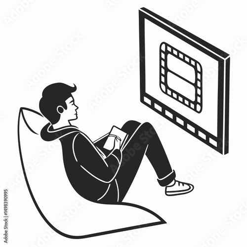 Young man relaxing beanbag watching film taking notes